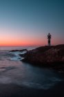 Leuchtfeuer an der Meeresküste bei majestätischem Sonnenuntergang am wolkenlosen Abend, Asturien, Spanien — Stockfoto