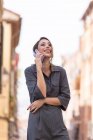 Весела жінка говорить по смартфону на вулиці — стокове фото