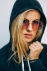 Junge blonde Frau mit Sonnenbrille blickt in die Kamera — Stockfoto