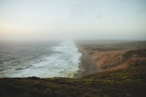 Foamy waves of beautiful sea waving near shore of Point Reyes during amazing sunrise in California — Stock Photo