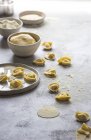 Raw tortellini in flour on grey tabletop — Stock Photo