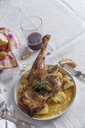 Gebratenes Lamm mit Kartoffeln auf Teller auf weißer Tischdecke serviert — Stockfoto