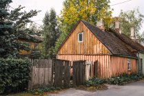 Rue de campagne avec clôture cassée et cabane en bois le jour d'automne — Photo de stock