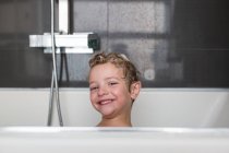 Porträt eines lächelnden kleinen Jungen in der Badewanne — Stockfoto