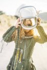 Femme confiante en costume d'astronaute portant un casque à la lumière du soleil — Photo de stock