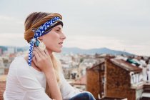 Frau mit Kopftuch steht auf Dach — Stockfoto