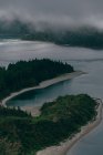 De cima vista do lago limpo azul cercado por colinas com nevoeiro cinza acima — Fotografia de Stock