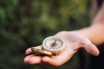 Close-up of female hand holding compass in nature — Stock Photo
