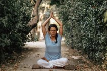 Donna tranquilla che fa yoga sul percorso nel giardino autunnale — Foto stock