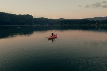 Жінка плаває на човні в чистому озері — стокове фото
