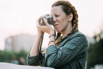 Pretty redhead girl with braids taking picture outdoors — Stock Photo