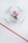 Дрон, загорнутий як різдвяний подарунок зі смугастою червоною та білою стрічкою на білому тлі — стокове фото