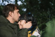 Paar im Wald schaut einander an und küsst sich — Stockfoto
