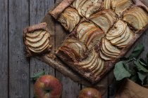 Hausgemachter Apfelkuchen auf schäbigem Holztisch — Stockfoto