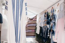 Verschiedene traditionelle Tuniken auf Kleiderbügeln auf dem Straßenmarkt, Mykonos, Griechenland — Stockfoto