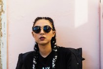 Trendige Brünette mit Piercing und Sonnenbrille blickt selbstbewusst in die Kamera — Stockfoto