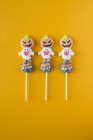 Halloween-Bonbons auf Stöcken auf orangefarbenem Hintergrund — Stockfoto