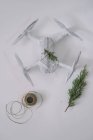 Беспилотник, завернутый в рождественский подарок с еловой веткой и бечевкой на белом фоне — стоковое фото