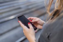 Женщина с помощью смартфона на железнодорожной станции — стоковое фото