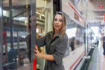 Mujer inclinada tren en la estación - foto de stock