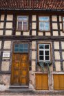 Fachada do edifício shabby envelhecido com porta de madeira e sinal — Fotografia de Stock