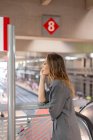 Жінка розмовляє на смартфоні на залізничній станції — стокове фото