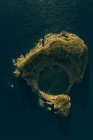 Veduta aerea di piccola isola rocciosa lavata dal mare blu calmo alla luce del giorno — Foto stock
