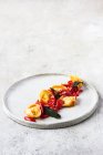 Delizioso piatto di tortellini con pomodori serviti su piatto su tavolo grigio — Foto stock