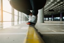 Nahaufnahme männlicher Füße in Turnschuhen, die auf Schienen im Gebäude laufen — Stockfoto