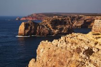 Costa del mare con alte scogliere e acqua blu — Foto stock
