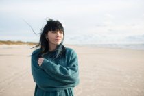 Женщина, стоящая на пляже и отворачивающаяся — стоковое фото