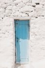 Блакитні старі дверцята в білих рок будівництво в Міконос, Греція — стокове фото