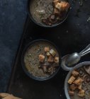 Mushroom cream soup with croutons in bowls on dark background — Stock Photo
