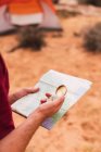 Crop man tenant carte et boussole rétro debout sur un fond flou de désert majestueux — Photo de stock