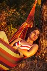 Frau liegt in Hängematte im sonnigen Wald — Stockfoto