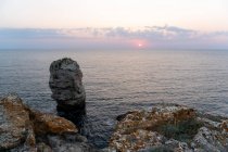 Incredibili rocce grezze in piedi in acqua di mare calma durante il bellissimo tramonto a Tyulenovo, Bulgaria — Foto stock