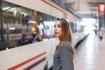 Уверенная женщина стоит на железнодорожной станции — стоковое фото