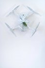 Drone wrapped as Christmas gift with elegant ribbon and fir branch on white background — Stock Photo