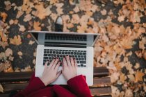 Woman with laptop sitting on bench — Stock Photo