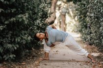 Donna magra che fa yoga sul vicolo nel parco autunnale — Foto stock
