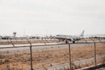 Airplane soaring from airport enclosed by security wire, Mykonos — Stock Photo