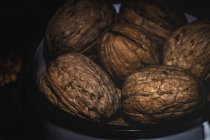 Dried walnuts in pan on black background — Stock Photo