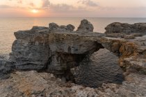 Rochas ásperas incríveis em pé na água do mar calma durante o belo pôr do sol em Tyulenovo, Bulgária — Fotografia de Stock