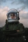 Girl wearing old space helmet and spacesuit against dramatic sky at sunset — Stock Photo