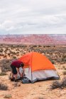 Reisender packt Rucksack und schließt Zelt — Stockfoto