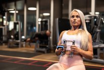 Athletische blonde Frau beim Turnen an Trainingsgeräten — Stockfoto