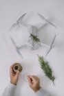 Male hands decorating wrapped drone as Christmas gift with fir branch and twine on white background — Stock Photo