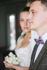 Bride looking to groom indoors — Stock Photo