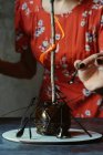 Жінка прикрашає Хеллоуїн яблуко з кристалізованою карамеллю — стокове фото