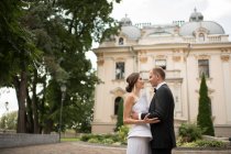 Coppia sposata che abbraccia vicino edificio di lusso — Foto stock